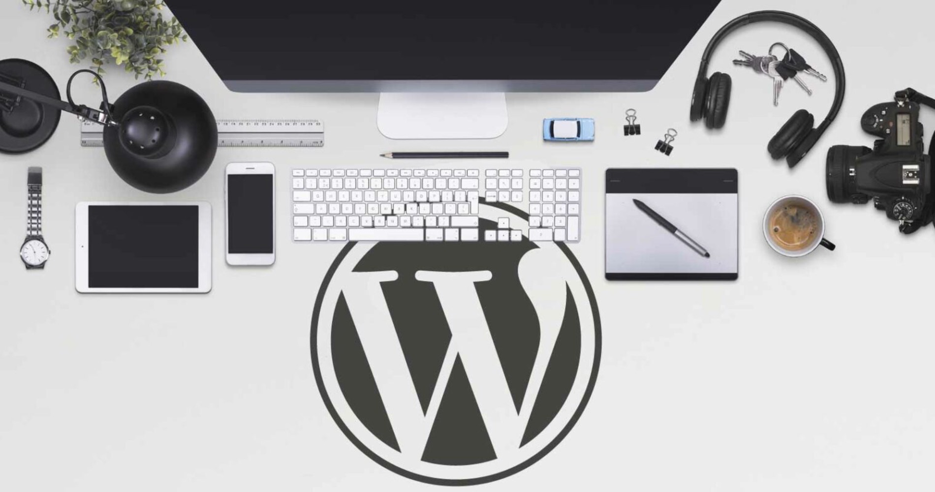 Desk setup with desktop and various accessories with the WordPress logo