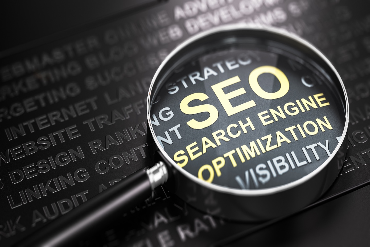 Magnifying Glass On Black Web Design Phrases. Under The Magnifier Is “Seo Search Engine Optimization” In Gold