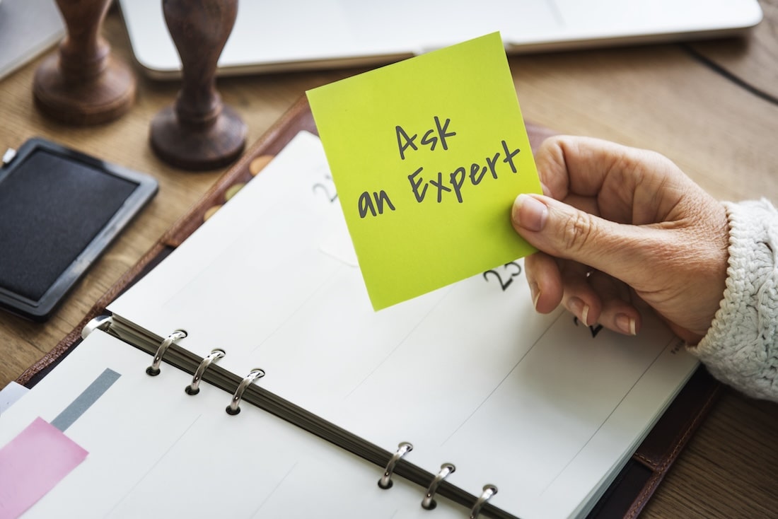 Paper with text "Ask an Expert" about How to write an FAQ page