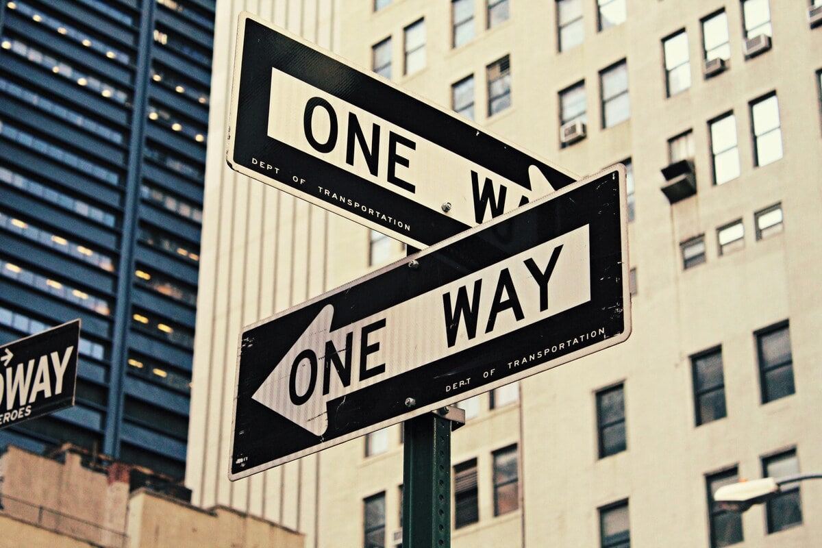 Two one way street signs pointing in opposite directions symbolizing custom vs template websites