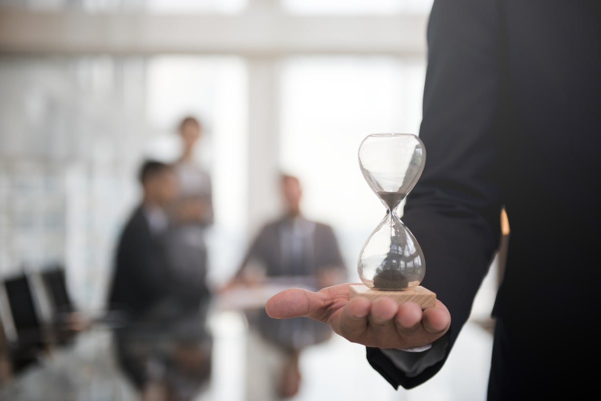 businessmanh holding hour-glass signifying the importance of being on time 