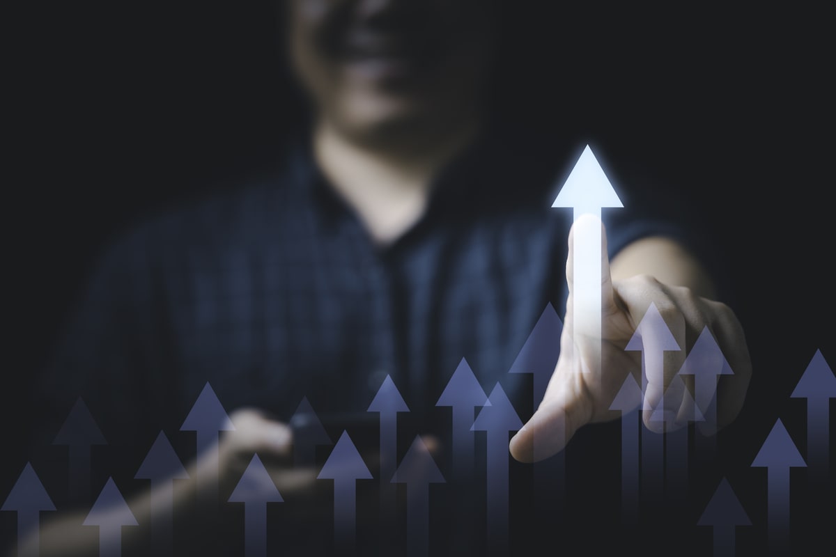 Businessman touching glowing increasing arrow to show growth concept