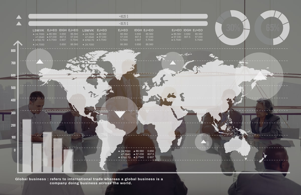 Global business graph showing growth statistics overlayed and a world map, with a blurred office workspace in the background featuring people working at desks