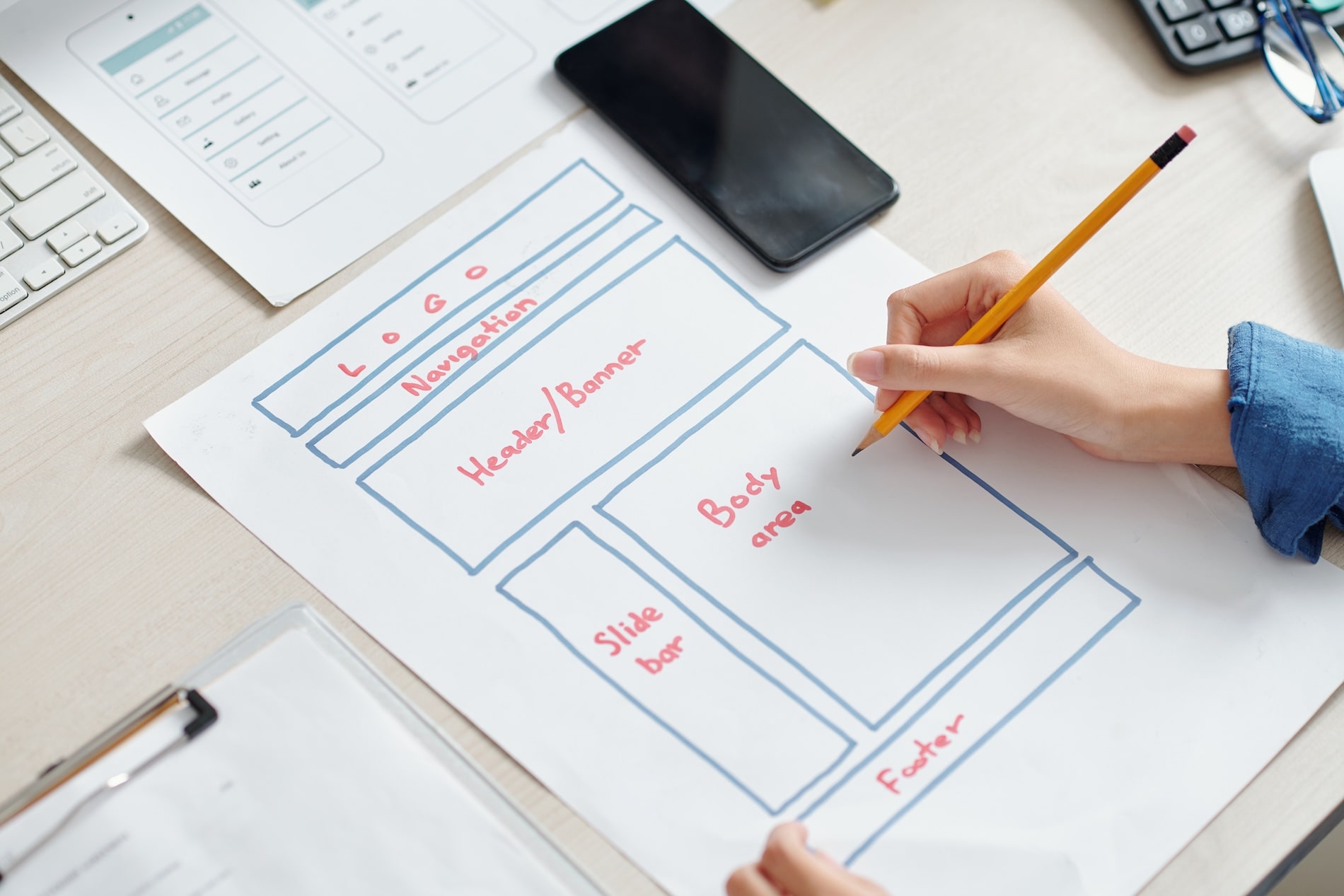 UI designer sketching a homepage wireframe layout as part of homepage design best practices.