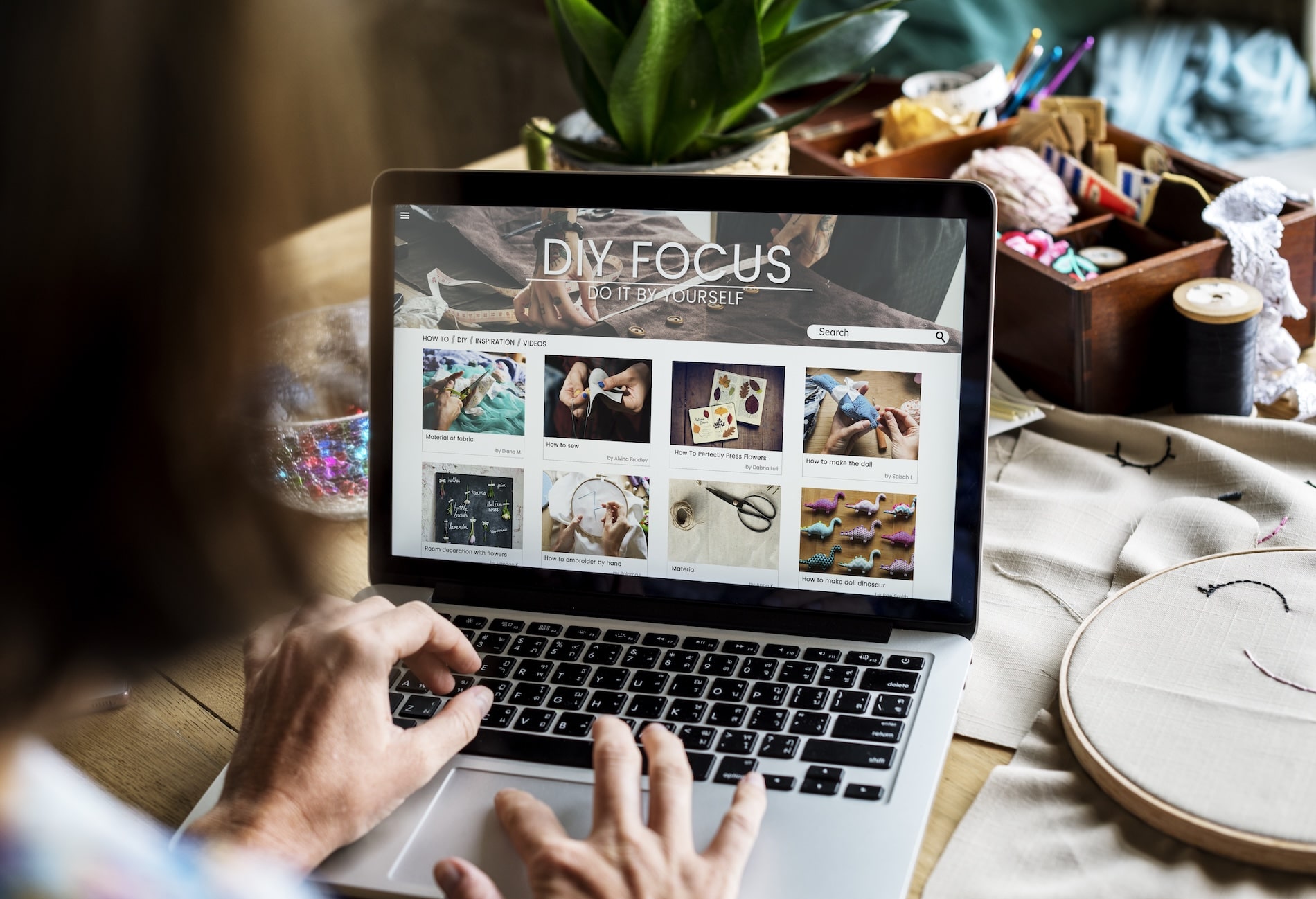 Woman browsing a DIY website on her laptop with homepage categories displayed clearly.