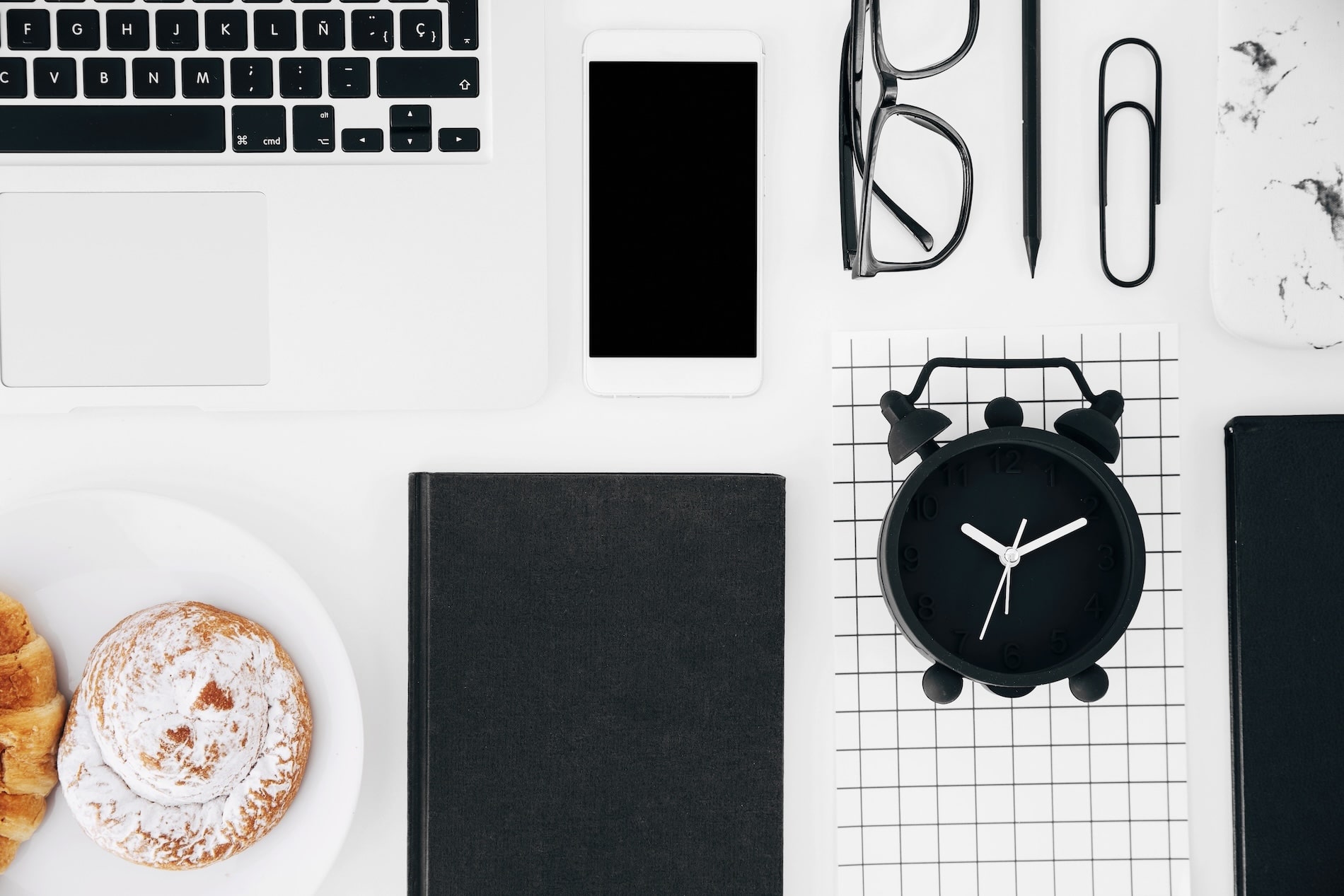 Flat lay with laptop smartphone alarm clock and notebook illustrating when is it time to invest in a website redesign